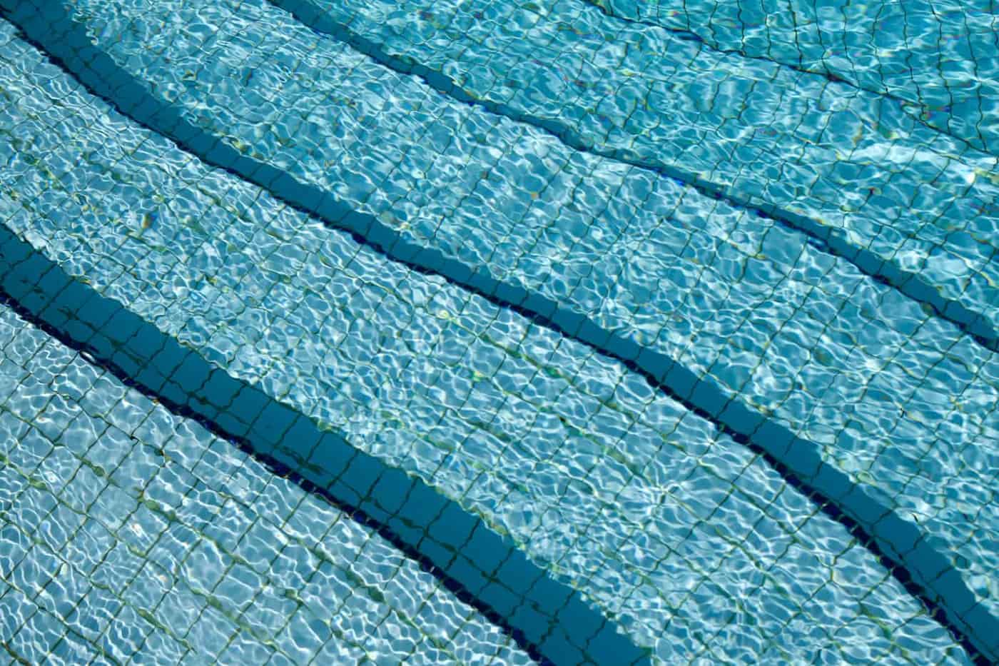 Calm, balanced swimming pool water reflecting the sky